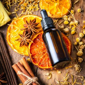 Aromarherapy: essential oil bottle, incense, dried oranges and scented spices on wooden table